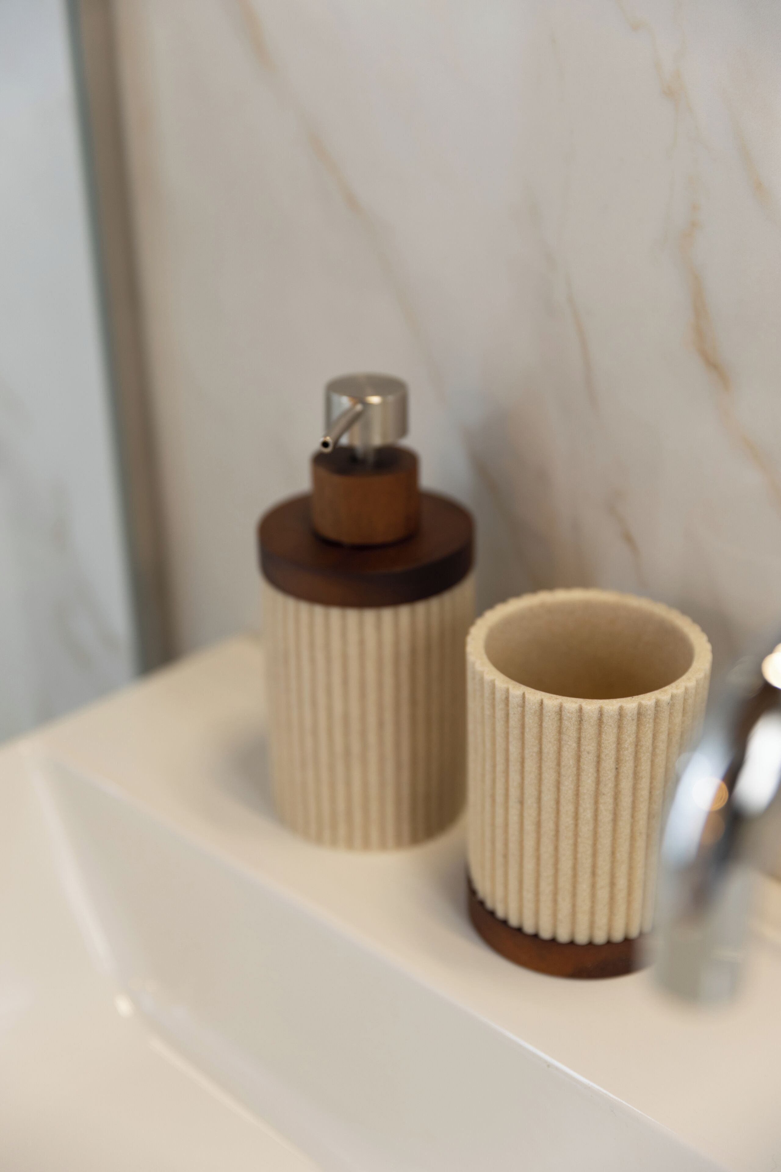 Un bagno con un lavandino bianco, un porta asciugamani e uno specchio.