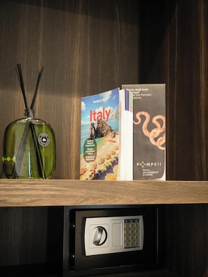 Un mini bar amb una ampolla verda, un llibre amb el títol 'Itàlia' i un fullet informatiu del 'Parc Arqueològic de Pompeia'.