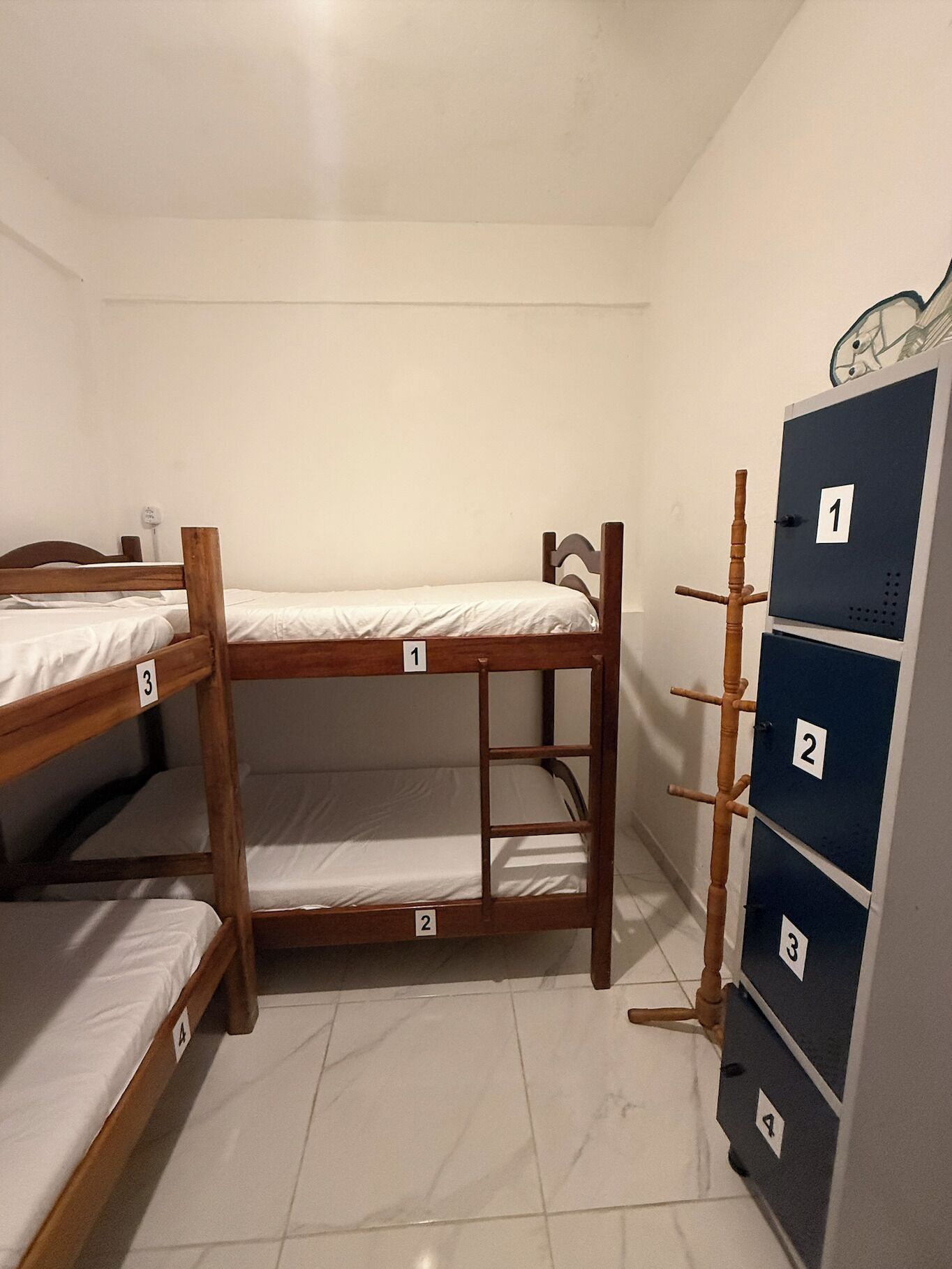 A room with bunk beds labeled 1, 2, and 3, and a set of lockers with numbers 1 to 4.