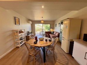 A compact kitchen with a dining table, chairs, a sofa, and a refrigerator. - Cozy apartment, air conditioning - 2 guests (Six-Fours-les-Plages)