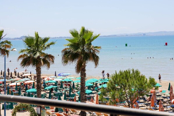 A beach with palm trees, umbrellas, and lounge chairs. - Toro Family Room With Sea View (Durrës)