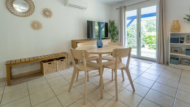 A modern living room with a dining table, chairs, a TV, and a large window with a view. - Duplex apartment with AC - 5 guests (Bias)