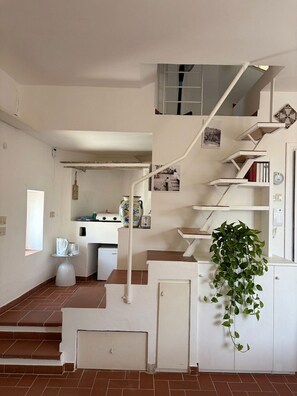 A staircase leading to a second floor with a plant on the landing.
