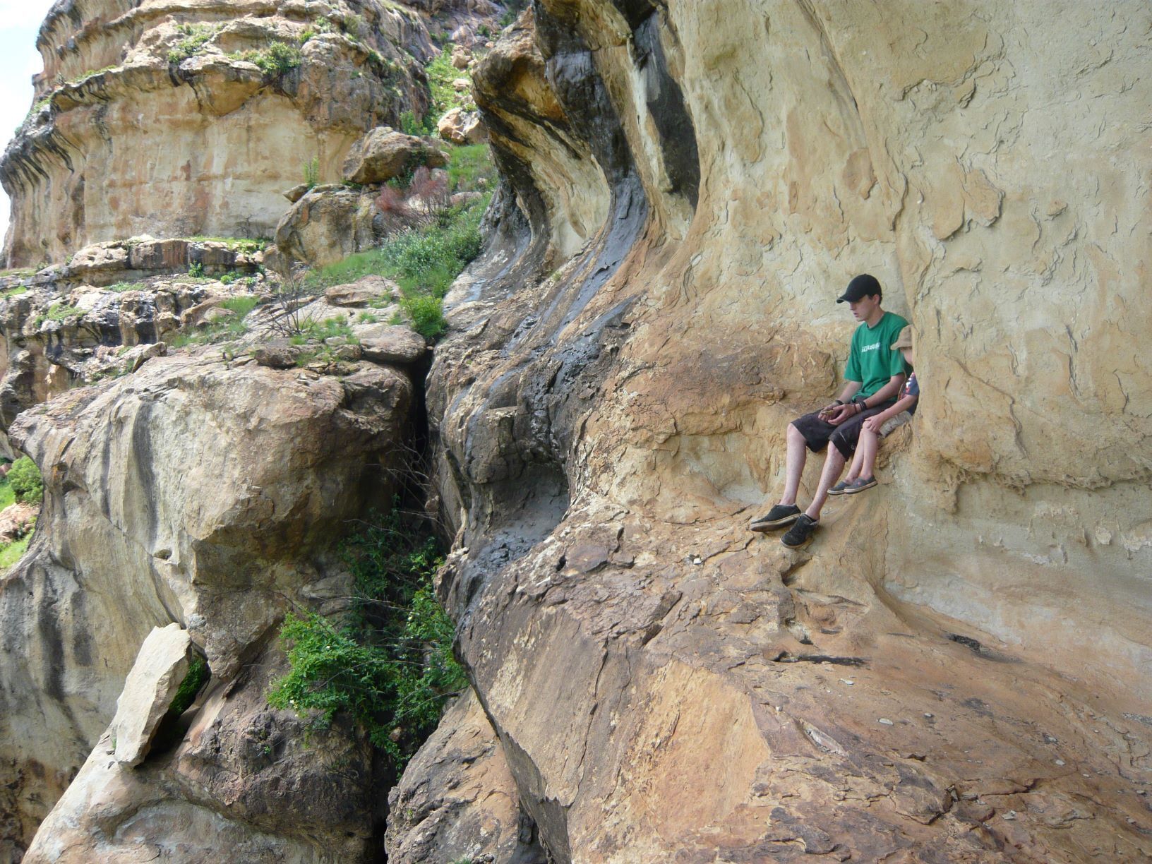 A person sitting on a rock formation.