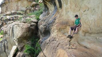 A person sitting on a rock formation.