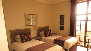 A hotel room with two beds, a window with curtains, and a framed picture on the wall. - Mafube Mountain Retreat (Fouriesburg)