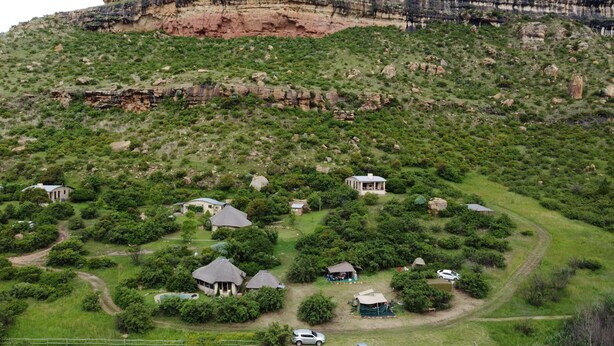A rural landscape with a large cliff and scattered houses. - Mafube Mountain Retreat (Fouriesburg)