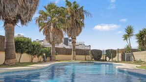 Una piscina rodeada de palmeras y edificios modernos.