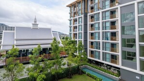 A modern hotel with multiple floors, balconies, and a swimming pool. - 1-Bedroom Ozone Apartment, Pool, Gym & Beach Shuttle (Thalang)