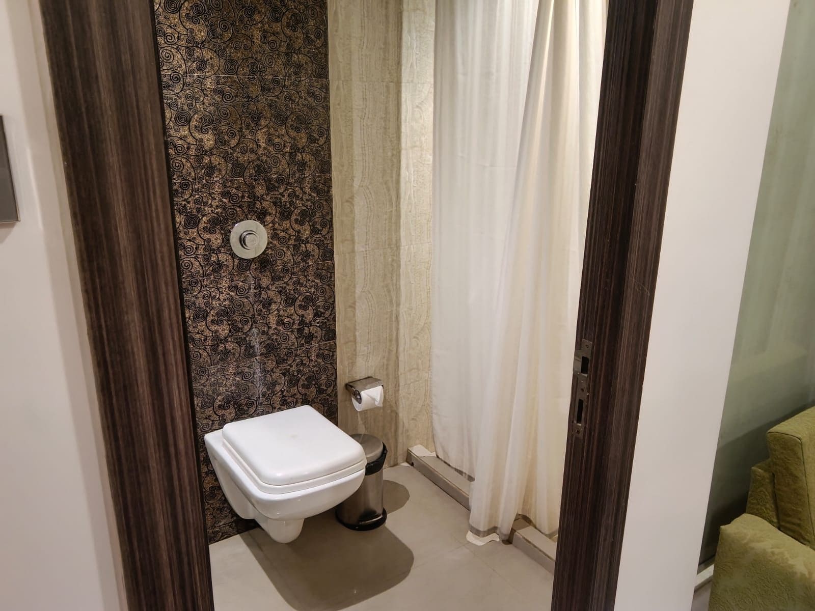 A bathroom with a toilet, a bidet, and a shower curtain.