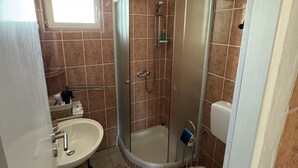 A bathroom with a shower, sink, toilet, and a window. - Apartment Didovi Dvori 2 With Jacuzzi (Razanac)