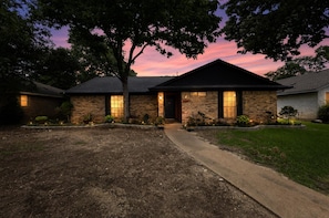 A brick house with a front entrance, a driveway, and a well-maintained lawn. - Central Frisco Family Getaway 3 Bedroom Home (Frisco)