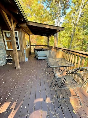 A wooden deck with a hot tub, outdoor seating, and a stone fireplace. - Blu's Blessed View 1 Bedroom Cabin (Sevierville)