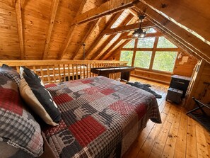 A cozy attic bedroom with a wooden ceiling, a bed with a quilt, a pool table, and a fireplace. - Blu's Blessed View 1 Bedroom Cabin (Sevierville)