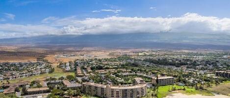 Un resort costero con varias construcciones, una playa y vista del paisaje lejano.