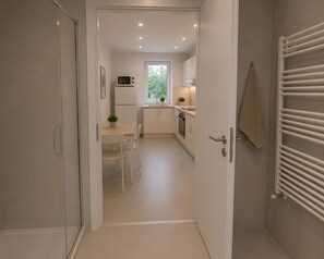 Eine moderne Küche mit weißen Schränken, einer Mikrowelle und einem Fenster.
