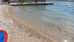 A pebble beach with clear water, a wooden pier, and trees. - Apartment 'Vivien' with Sea View, Wi-Fi and Air Conditioning (Kustići)