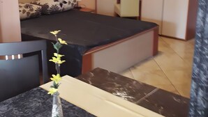 A small, compact room with a bed, a desk, a chair, a cabinet, and a painting on the wall. - Apartment 'Vivien' with Sea View, Wi-Fi and Air Conditioning (Kustići)
