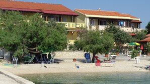 A beachside property with a pool, outdoor seating, and a view of the sea. - Apartment 'Vivien' with Sea View, Wi-Fi and Air Conditioning (Kustići)