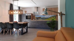 Eine moderne Küche mit Essbereich, einer Couch und einem Gemälde an der Wand.