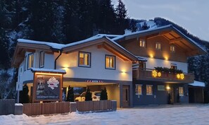 Ein mehrstöckiges Hotel mit einer Seilbahn im Hintergrund, was auf eine Lage in der Nähe eines Skigebiets hindeutet.