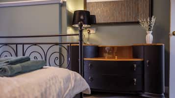 A bedroom with a bed, a dresser, a mirror, and a lamp.