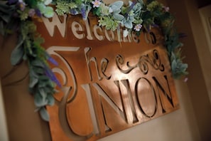 A welcome sign with the name 'The Cove' and 'ION' partially visible, surrounded by greenery.