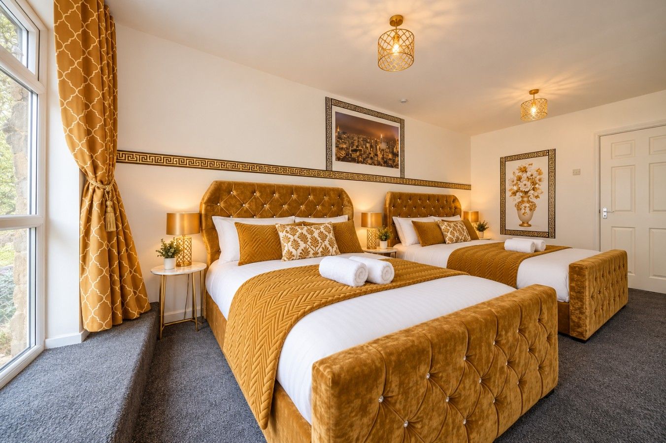 A hotel room with two beds, a large window with curtains, a cityscape picture on the wall, and a decorative ceiling light.