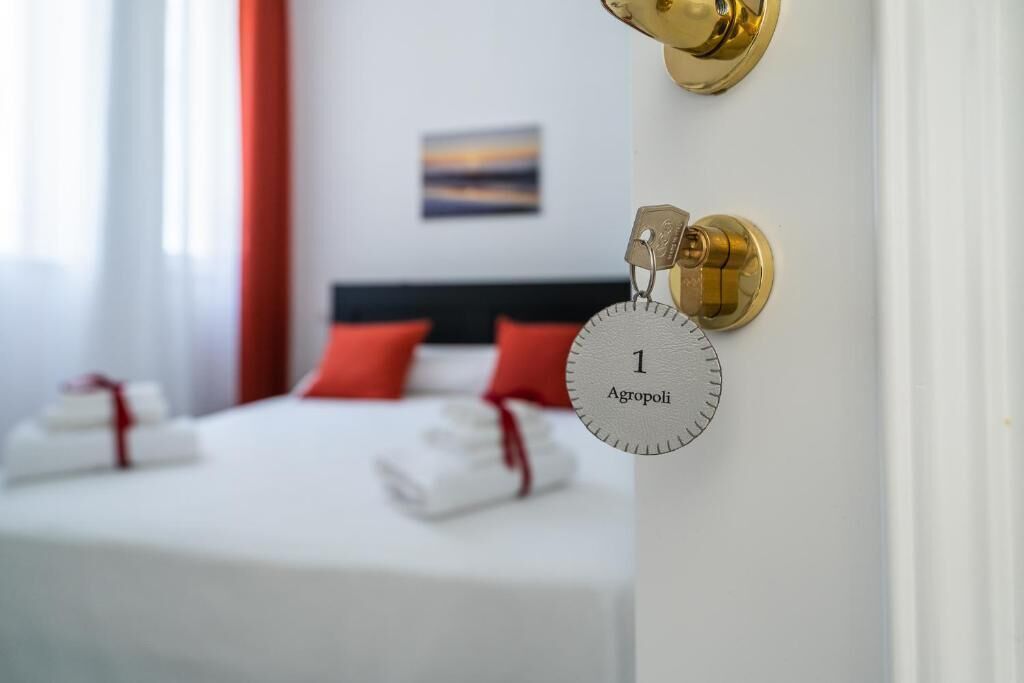 Habitación de hotel con una cama, una tarjeta de llave y un candado en la pared.