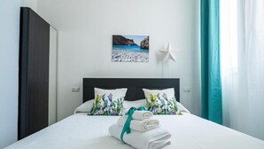 A hotel room with a bed, pillows, a star-shaped light, and a beach scene painting. - Domus Mare Cilento (Agropoli)