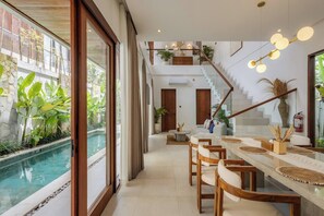 Ein modernes Interieur mit Pool, Holzmöbeln und einer Treppe.