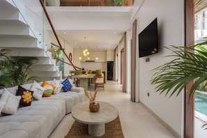 Ein modernes Wohnzimmer mit Sofa, Couchtisch und Treppe.