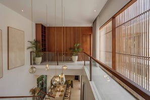 Ein modernes Interieur mit Essbereich, Holzvertäfelung und großen Fenstern.