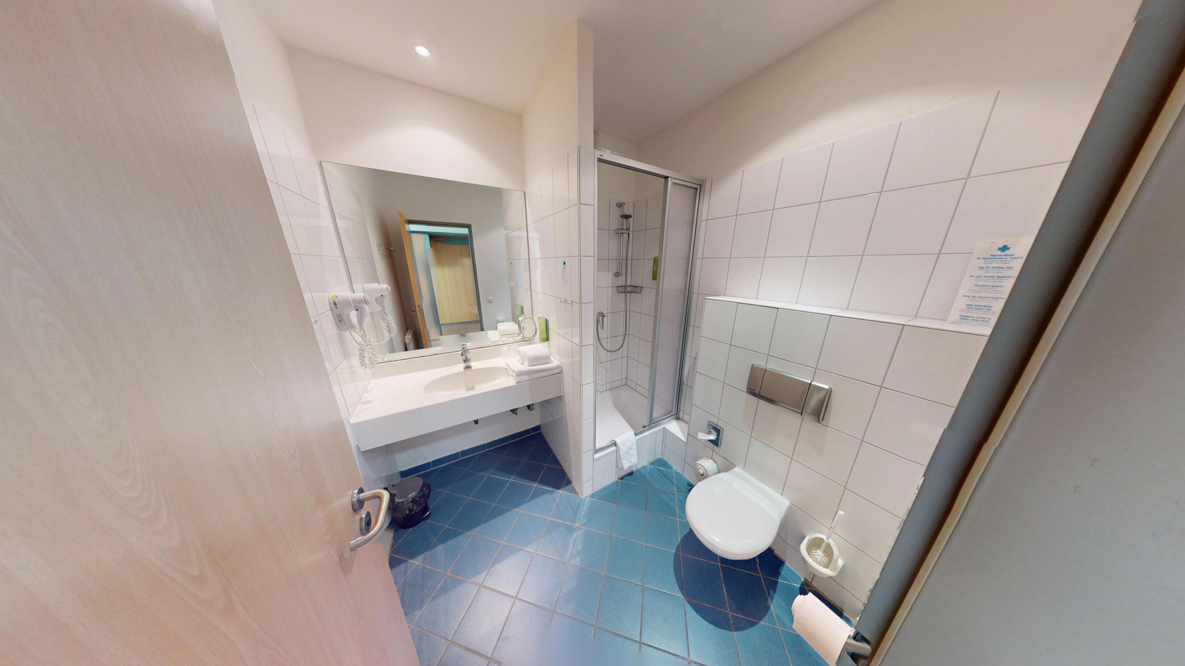 Une salle de bain avec une douche, un lavabo et des toilettes.