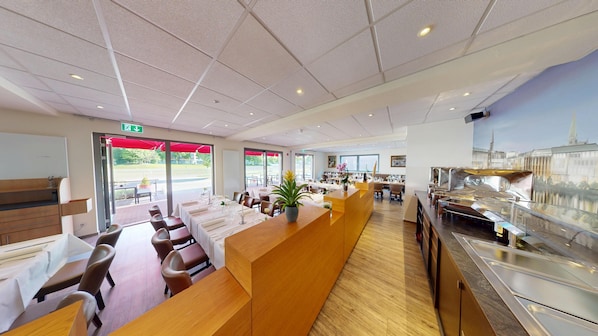 Un hall dâhĂŽtel moderne comprenant un comptoir dâaccueil, un espace salon et un buffet.