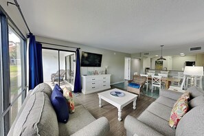 Ein geräumiges Wohnzimmer mit einer Couch, einem Couchtisch und einem Fernseher.