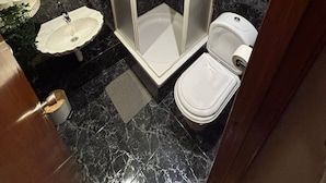 Ein Badezimmer mit Duschkabine, Waschbecken und Toilette.