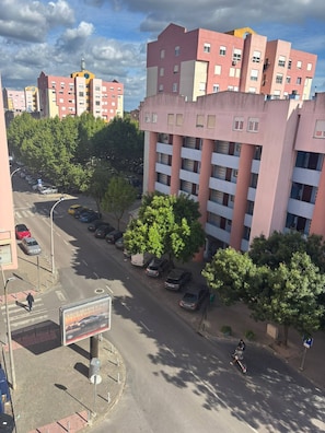 Ein mehrgeschossiges Wohngebäude mit Parkplatz und Bäumen.