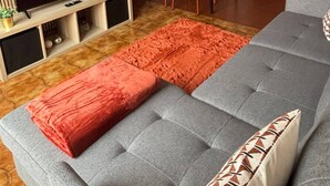 Ein modernes Wohnzimmer mit einer Couch, Fernseher und Essbereich.
