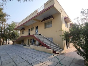 A two-story building with a staircase leading to a balcony. - Shangov Farms Shamirpet (Shamirpet)