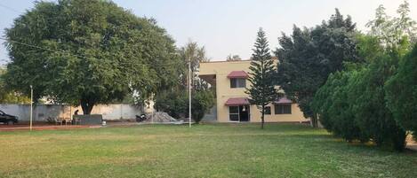 A building with a flat roof, a small porch, and a paved driveway.