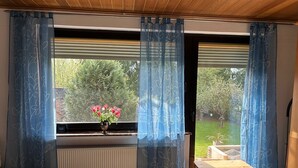 Et soveværelse med et vindue, en radiator, et trænatbord og en seng.