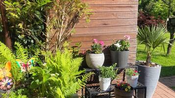 A garden with potted plants, a wooden structure, and a brick pathway.