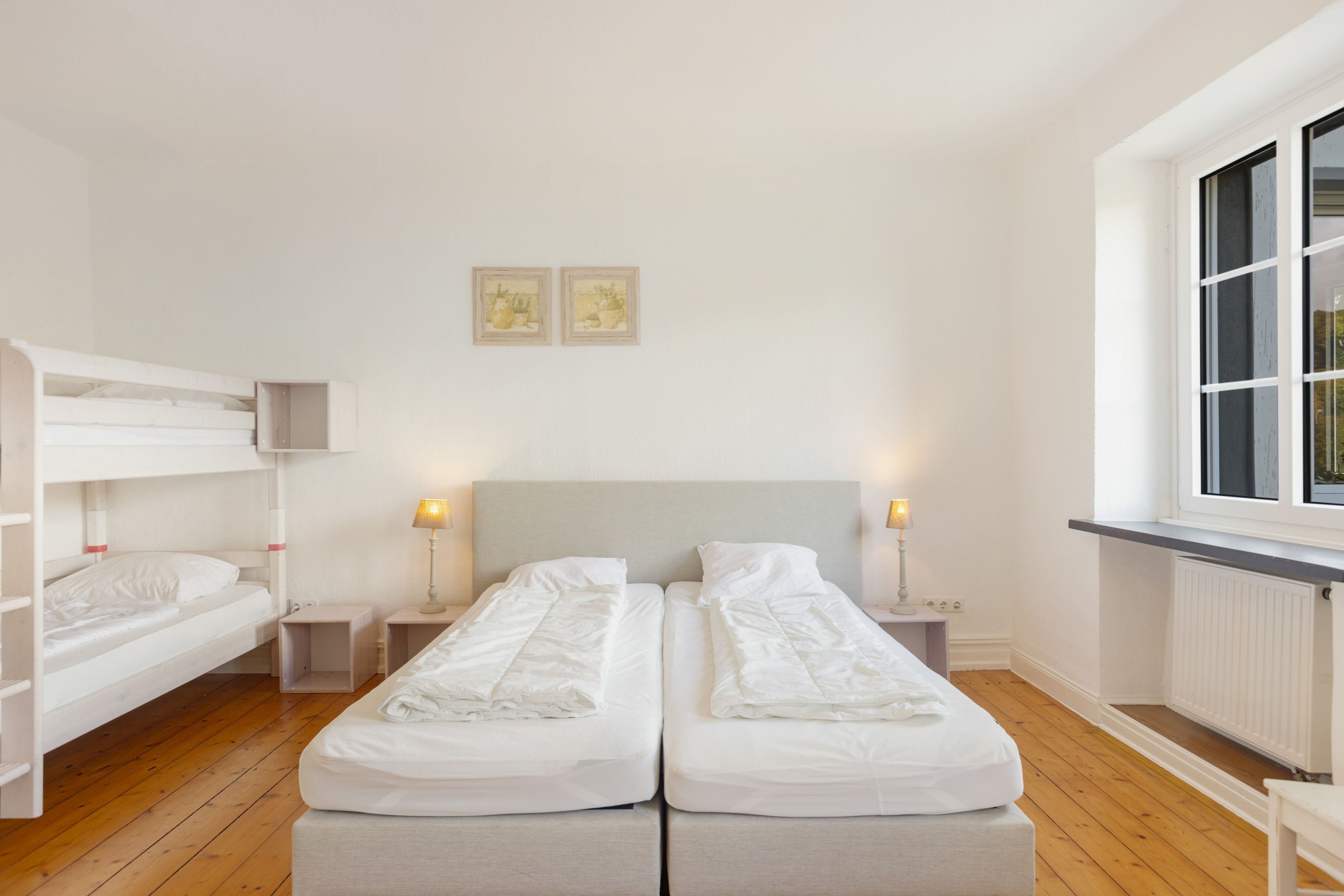 Habitación de hotel con dos camas individuales, una ventana y un radiador.