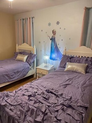 Un dormitorio con dos camas, una mesita de noche y un mural en la pared.