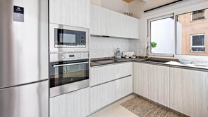 Une cuisine moderne dotée d’appareils électroménagers intégrés, d’une fenêtre offrant une belle vue et d’un plafond en bois.