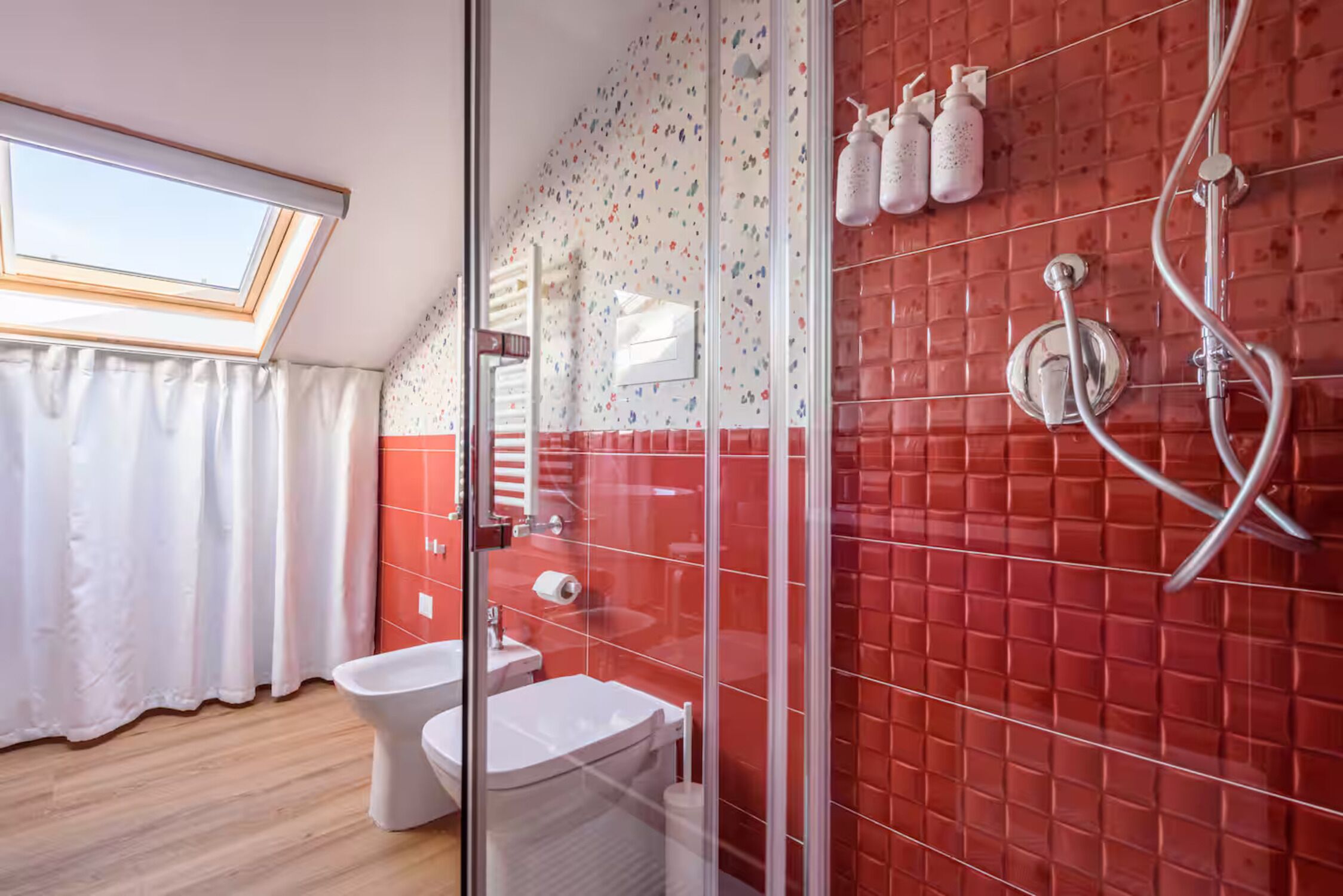 Un baño con tragaluz, ducha con cabina de vidrio y retrete.