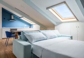 A room with a bed, a desk, and a chair, with skylights above. - Casalina by Napoliapartments (Naples)
