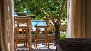 A poolside area with wooden chairs and a stone bowl. - Vacation home Prana by Interhome (Moraira)