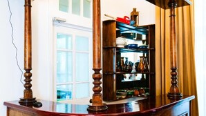 A wooden bar counter with a shelf of kitchenware in the background. - Officers Boutique (Samarkand)